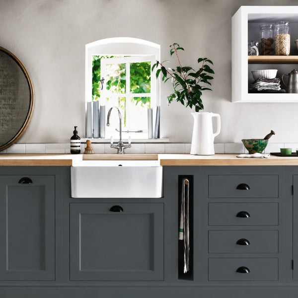 Smoke grey painted Henley kitchen cabinetry with oak worktops and a white farmhouse sink.
