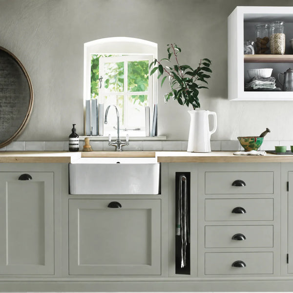 Moss sage green painted Henley kitchen cabinetry with oak worktops and a white farmhouse sink.