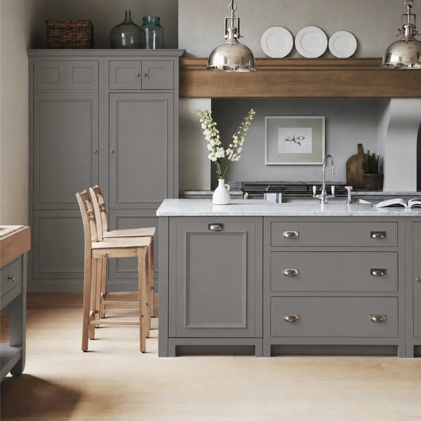 Chichester kitchen with cabinetry painted in Shale grey, featuring a central island and oak bar stools.