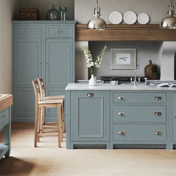 Chichester kitchen with cabinetry painted in Aqua Blue, featuring a central island and oak bar stools.