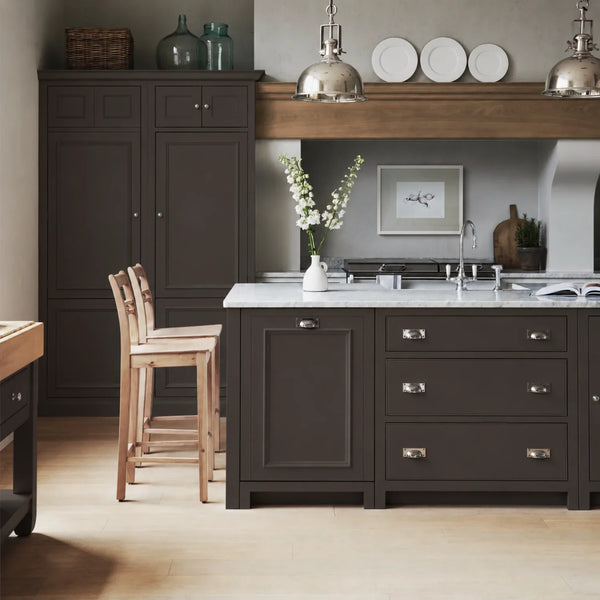 Chichester kitchen with cabinetry painted in Walnut dark brown, featuring a central island and oak bar stools.