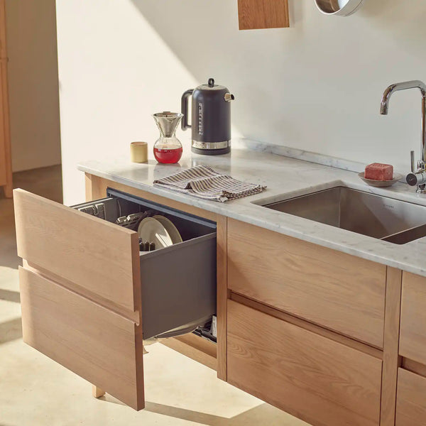 Borough oak sink cabinet with marble worktop, undermount sink and integrated dishwasher drawer open.