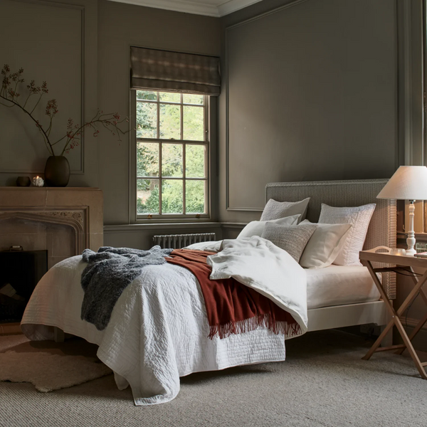 Albertine Bed Linen Set in a calm, traditional bedroom with panelled walls and fireplace