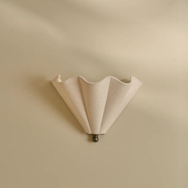 Athena linen scalloped wall light with bronze accents on beige wall