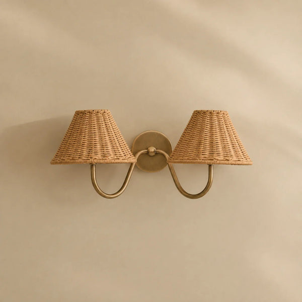 Athena brushed brass double wall light with rattan lampshades on cream wall