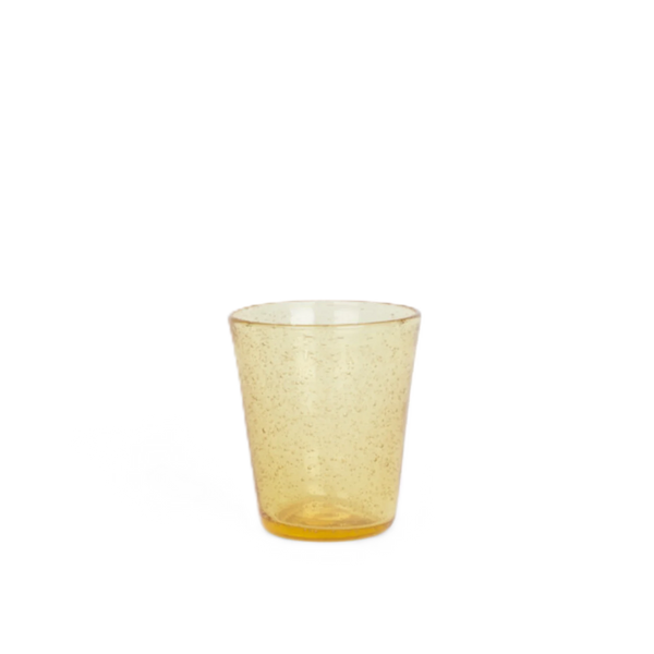 A small translucent amber glass tumbler with fine speckles, shown on a plain white background.