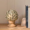 Eversley footed ceramic artichoke decorative ornament displayed on wooden bookshelf