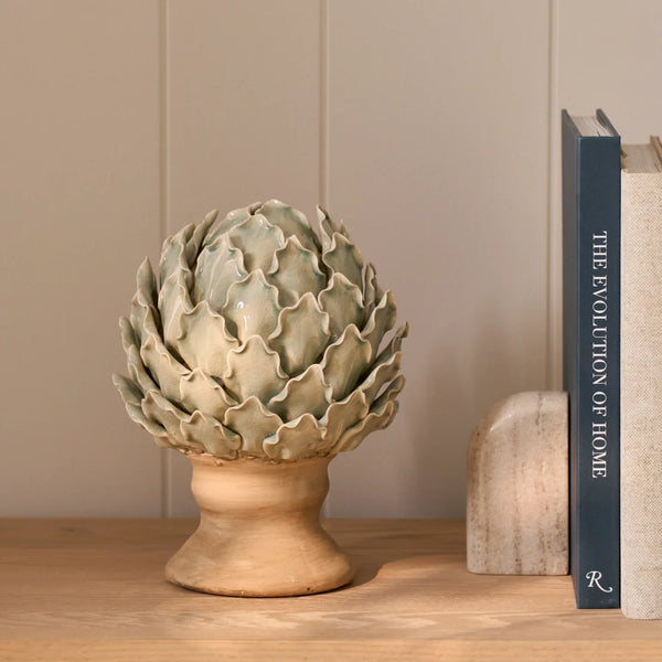 Eversley footed ceramic artichoke decorative ornament displayed on wooden bookshelf
