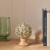 Eversley footed ceramic artichoke decorative ornament displayed on wooden bookshelf with vase