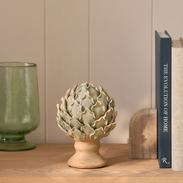 Eversley footed ceramic artichoke decorative ornament displayed on wooden bookshelf with vase