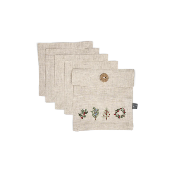 Four square beige linen pouches stacked in a fan arrangement on a white background. The front pouch has a wooden button closure and embroidered holiday motifs including holly, mistletoe, and a wreath.