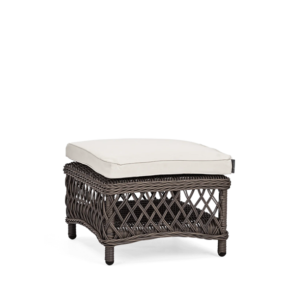 A square outdoor ottoman with a dark brown woven wicker frame and a thick, square off-white cushion, shown on a solid white background.