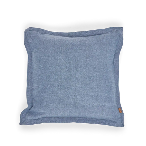 A square blue throw pillow with a textured fabric cover and a small orange tag on the bottom right corner, shown against a plain white background.