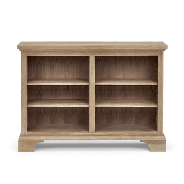 A light oak wood low bookcase with two columns of three open shelves, shown from a front angle on a white background.