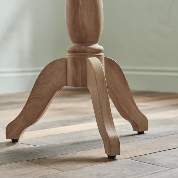 Wooden pedestal leg on a wooden floor with a neutral background