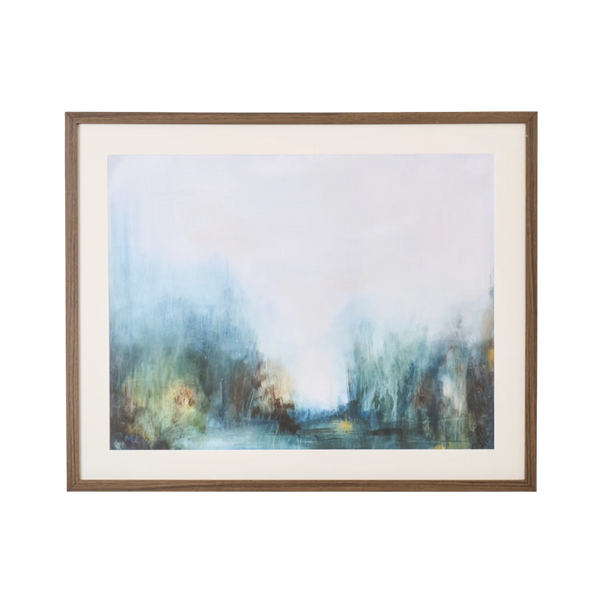 A framed abstract landscape painting featuring soft blue, green, and brown brushstrokes, presented with a wide cream mat and a medium brown wooden frame against a plain white background.