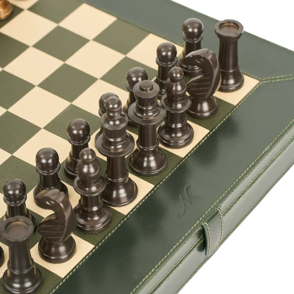 Close-up of a chess set in a green leather case, showing dark chess pieces arranged on a green and cream checkered board.