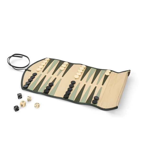 A rolled leather backgammon board with black and cream checkers, a black carrying strap, and several dice, photographed on a clean white background.