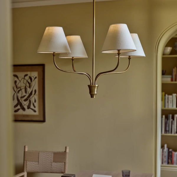Regency small four light pendant in brass with linen shades, shown in elegant office