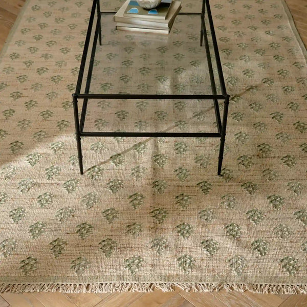 Rona rug in cactus shown with wooden parquet flooring and glass coffee table