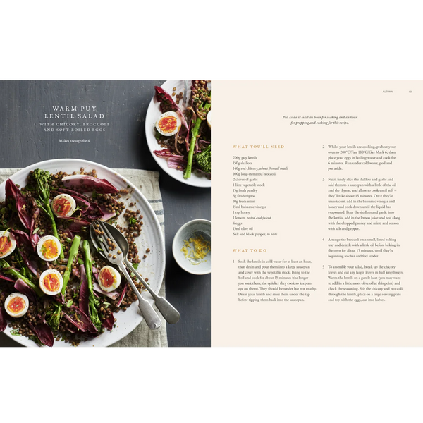 An open cookbook spread showing a recipe for Warm Puy Lentil Salad. The left page features a styled food photograph of the salad with red cabbage, asparagus, lentils, and halved egg slices on a rustic grey surface.