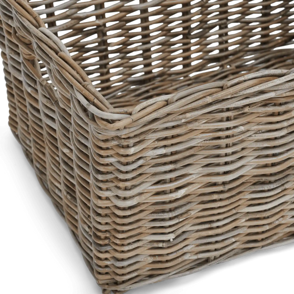 Close-up of a woven wicker basket corner showing natural tan and light brown interlaced strands on a white background.