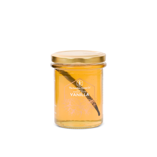 A glass jar of vanilla honey with a gold metal lid, featuring a white printed label that reads 'The Vanilla Honey Co. VANILLA'.