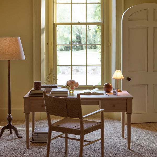 Thornbury darkened oak floor lamp in elegant office space next to desk and chair in front of large window overlooking a garden