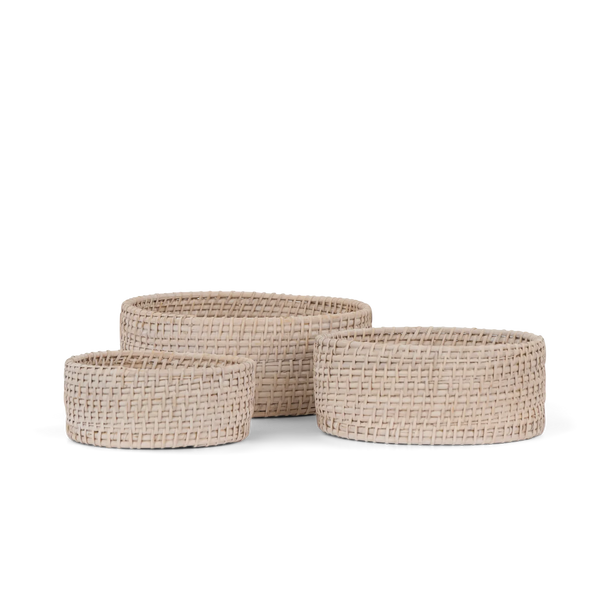 Three round woven storage baskets in a nested set, made from natural beige seagrass or wicker, shown on a clean white background.