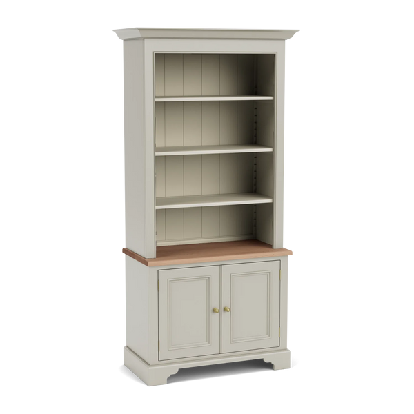 Angled view of the Chichester 3ft bookcase, with open upper shelving, a natural oak surface, lower panelled cupboard doors and a traditional painted timber frame.
