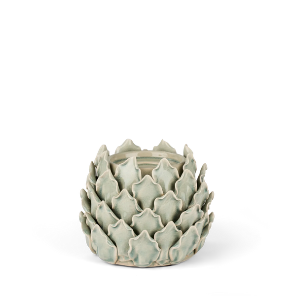 A ceramic art deco style candle holder shaped like a lotus flower, featuring a pale sage green glaze and a light brown unglazed base, set against a plain white background.
