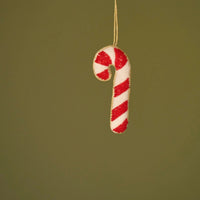Candy cane ornament on a green background