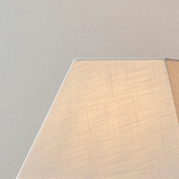 A close-up of a light beige fabric or textured material swatch against a neutral off-white background.