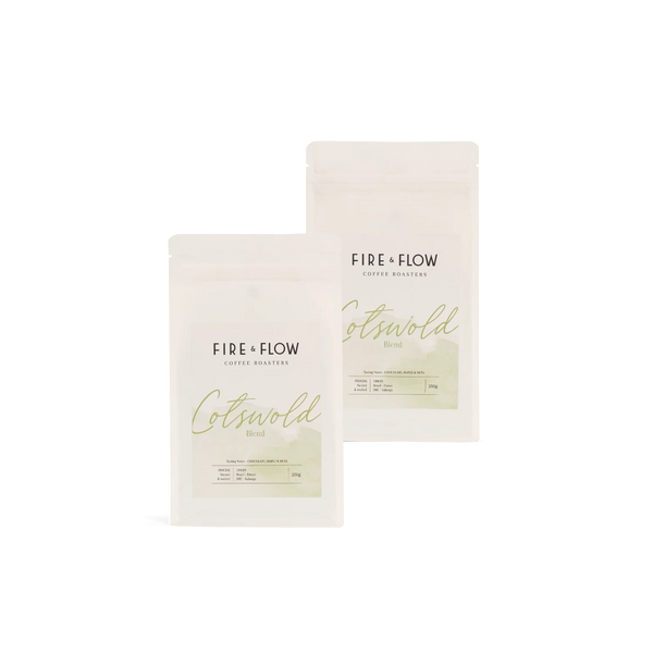 Two stand-up pouches of Fire + Flow Coffee Roastery Cotswold Blend coffee on a clean white background.